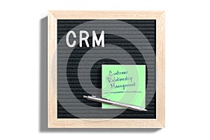 Acronym CRM on a letterboard with a note explaining it as `Customer Relationship Management`