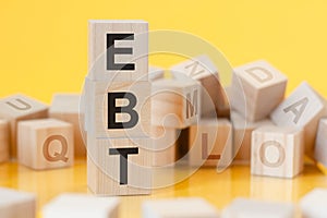 Acronym ebt from wooden blocks with letters, concept