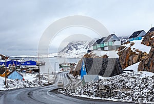 Acrtic road to the docks and port between the rocks with Inuit houses, Sisimiut, Greenland