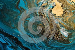 Acrylic Fluid Art. Blue waves and gold inclusion. Abstract stone background or texture