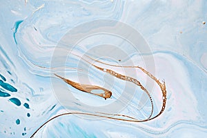 Acrylic Fluid Art. Liquid gold waves on blue watercolor background. Abstract marble background or texture