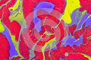 Acrylic Fluid Art. Red, violet and yellow color mixing with gold inclusions. Abstract wavy background or texture