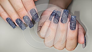 Acrylic nail extension, manicure, nail correction, hands in the foreground. Reflective design.