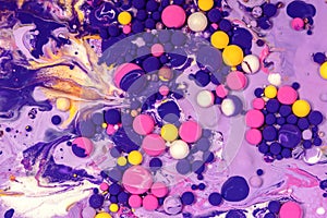 Acrylic paint balls abstract texture. Purple, blue, pink and yellow liquids mix. Creative multicolor background. Bright