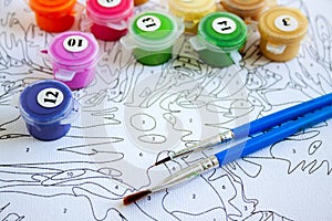 Acrylic paints in jars and brushes on canvas with markings - painting by numbers, hobbies