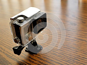 Action Cam in Waterproof Camera Housing Case on Wood Desk