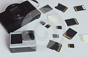 Action camera, digital camera and SD and MicroSD memory cards. Background from gadgets and digital devices