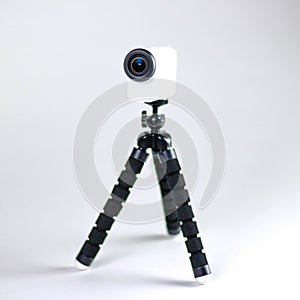Action camera on a small tripod. Close up. Isolated on white background