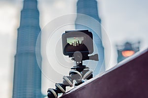 Action camera on a tripod records a video of the time-lapse of a big city