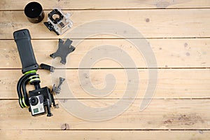 Action camera on the wooden table with a stabilizer