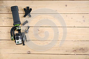 Action camera on the wooden table with a stabilizer