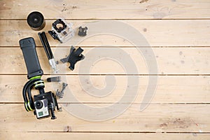 Action camera on the wooden table with a stabilizer