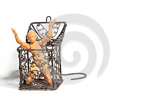 Action figure sitting and hold two hands above the head in open steel cage on isolate background, Concept of tolerance in comfort