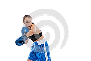 In action, motion. Young girl, professional boxer practicing in boxing gloves isolated on white studio background