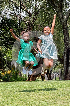 Action shot of African kids jumping in the garden