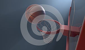An action shot of a regular basketball teetering on the rim of a red basketball hoop photo