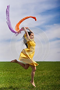 Young woman jumping for joy on a wheat field