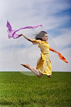 Young woman jumping for joy on a wheat field