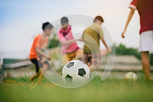 Action sport outdoors of a group of kids having fun playing soccer football for exercise