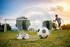 Action sport outdoors of kids having fun playing soccer football for exercise in community rural area under the twiligh