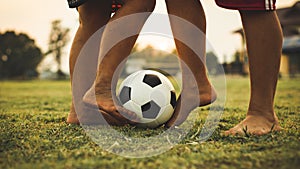 Action sport picture of a group of kids playing soccer football for exercise in community rural area under the sunset.