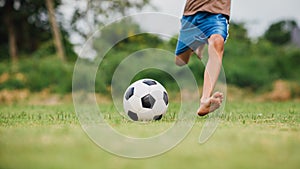 Action sport scene of a group of kids having fun playing soccer football for exercise in community rural area under the twilight s