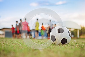 Action sport scene of a group of kids having fun playing soccer football for exercise in community rural area under the twilight s