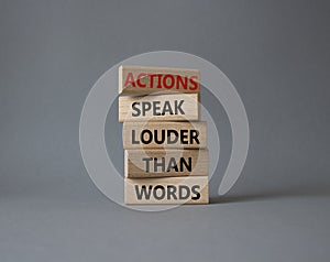 Actions speak louder than Words symbol. Wooden blocks with words Actions speak louder than Words. Beautiful grey background.