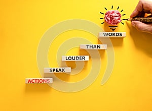 Actions speak louder words symbol. Concept words Actions speak louder than words on wooden blocks. Beautiful yellow table yellow