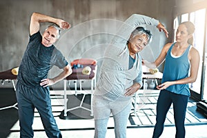 Activate a healthy retirement and join the gym. a senior man and woman working out with the help of an instructor.