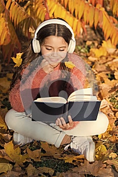 Activate listening. Small child in headphones practice listening comprehension. Little girl read book listening to audio photo
