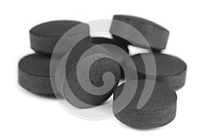 Activated Carbon (Activated Charcoal) Pills on White Background photo