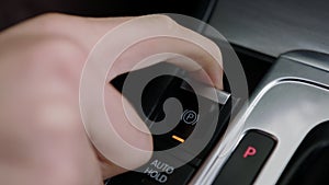 Activating the emergency parking brake of a car with an electronic button. Pressing the switch to turn the function ON