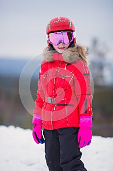 Active adorable preschooler caucasian girl portrait with ski in helmet  goggles and bright suit enjoy winter extreme sport