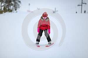 Active adorable preschooler caucasian girl portrait with ski in helmet, goggles and bright suit enjoy winter extreme sport