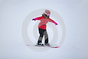 Active adorable preschooler caucasian girl portrait with ski in helmet, goggles and bright suit enjoy winter extreme sport