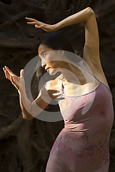 Active adult woman dancing with earthy tree roots in Connecticut