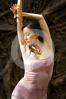 Active adult woman dancing with earthy tree roots in Connecticut