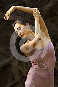 Active adult woman dancing with earthy tree roots in Connecticut