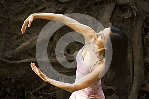 Active adult woman dancing with earthy tree roots in Connecticut
