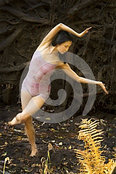 Active adult woman dancing with earthy tree roots in Connecticut