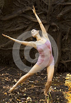 Active adult woman dancing with earthy tree roots in Connecticut