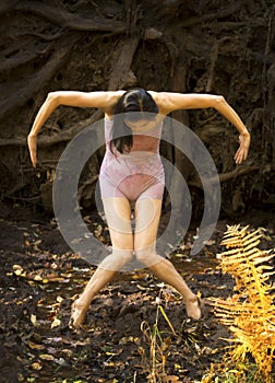 Active adult woman dancing with earthy tree roots in Connecticut