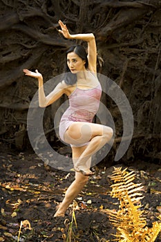 Active adult woman dancing with earthy tree roots in Connecticut