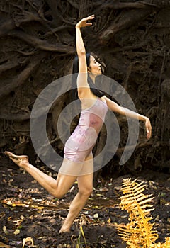 Active adult woman dancing with earthy tree roots in Connecticut