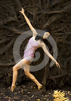 Active adult woman dancing with earthy tree roots in Connecticut