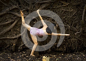 Active adult woman dancing with earthy tree roots in Connecticut