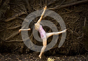 Active adult woman dancing with earthy tree roots in Connecticut