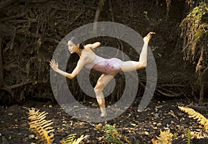 Active adult woman dancing with earthy tree roots in Connecticut