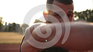 Active, angry male boxer training process on the outdoors stadium. Portrait of a man boxing with invisible opponent